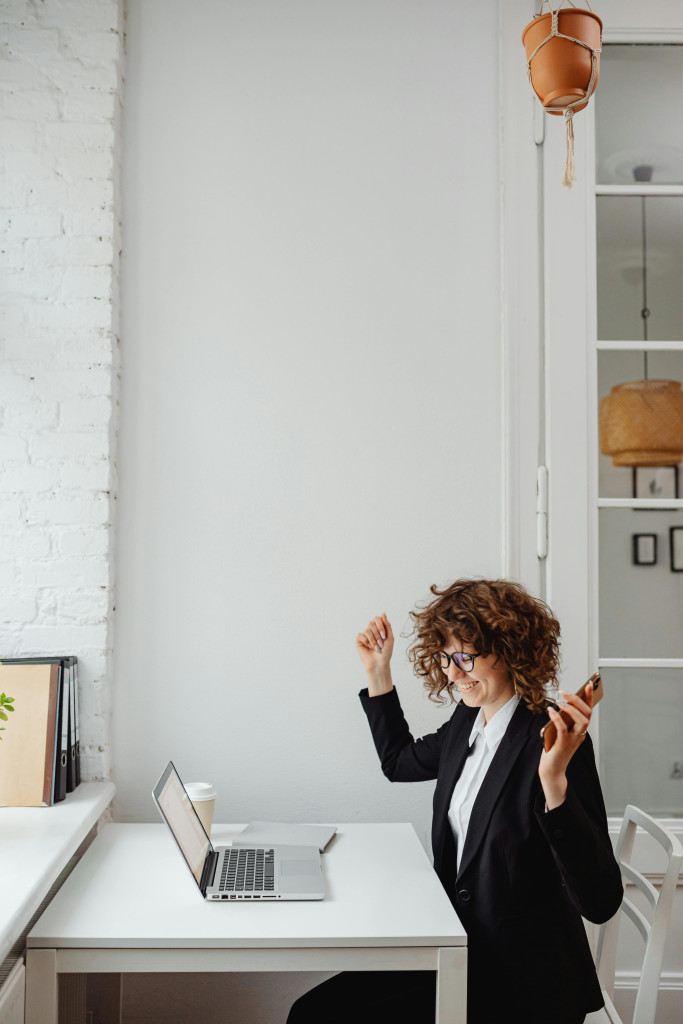 A happy businesswoman celebrates at her desk
